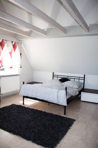 a bedroom with a bed and a black rug at Ferienwohnung Wolf in Veringenstadt