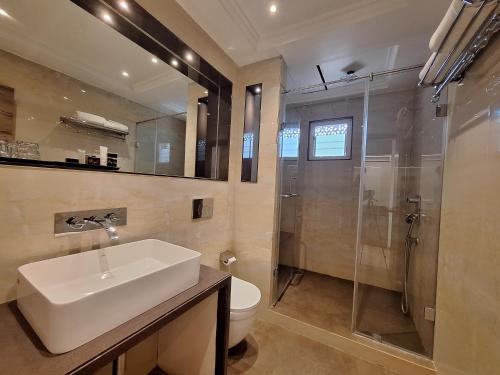 W łazience znajduje się umywalka, prysznic i toaleta. w obiekcie The Utopia Resort Sanchi w mieście Sānchi
