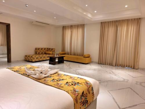 The Utopia Resort Sanchi في Sānchi: غرفة نوم بسرير كبير وغرفة معيشة