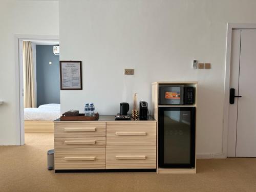 eine Küche mit einer Theke, einer Mikrowelle und einem Kühlschrank in der Unterkunft Al ATLAL apartment in Nizwa