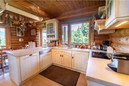 a kitchen with white cabinets and a large window at The Flysch in Miríki