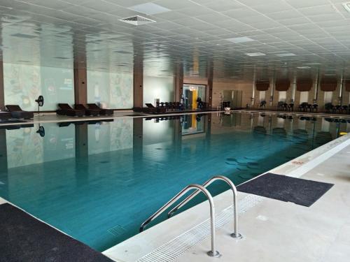 a large swimming pool with blue water in a building at Parkway Apartments in Rawalpindi