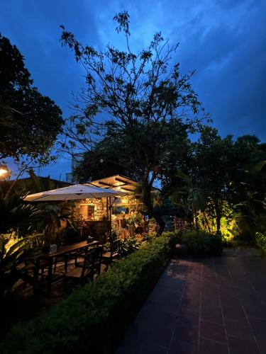 a restaurant with tables and umbrellas at night at Thom's House in Ninh Binh