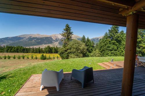 a deck with two chairs and a view of mountains at The Flysch in Miríki