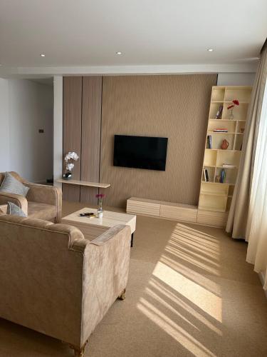 a living room with a couch and a flat screen tv at Al ATLAL apartment in Nizwa