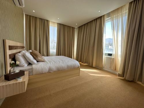 a bedroom with a bed and a large window at Al ATLAL apartment in Nizwa