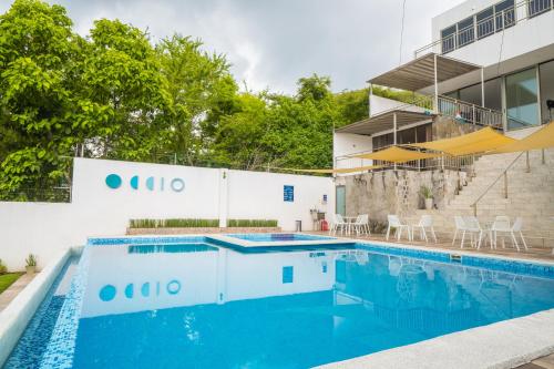 a swimming pool in front of a building at Equinoccio Hotel in Santa Ana