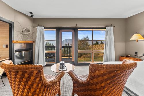 a living room with a table and chairs and a large window at Sun Mountain Lodge in Winthrop