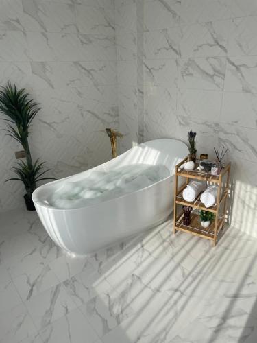 a white bath tub in a bathroom with marble walls at Al ATLAL apartment in Nizwa