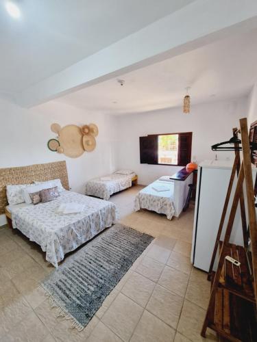 uma sala de estar com duas camas e uma televisão em Pousada Lua de Jeri em Jericoacoara