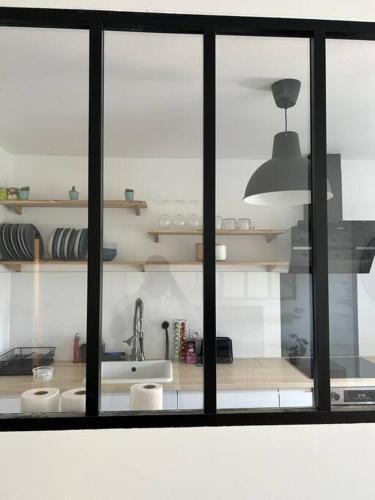 - une cuisine avec une fenêtre, un évier et un comptoir dans l'établissement Appart Cosy de 52m2, à Asnières-sur-Seine
