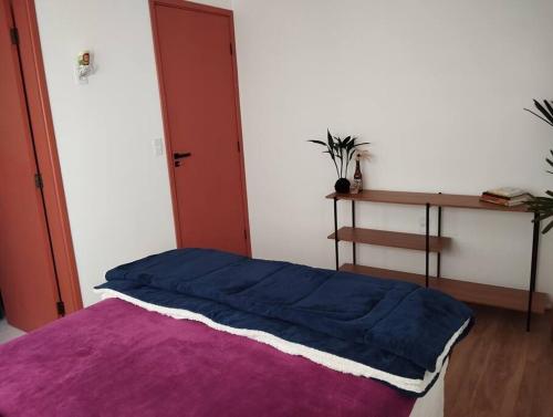 a bedroom with a blue blanket on a bed at Aconchego nas Montanhas in São Thomé das Letras