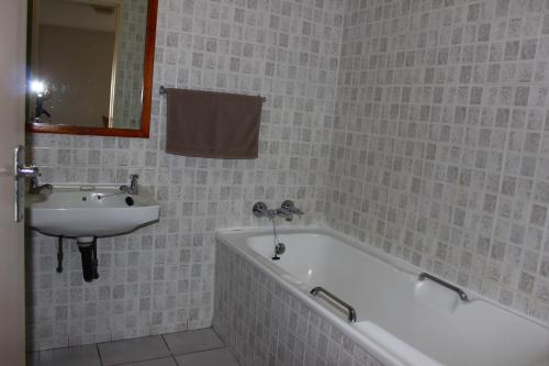 un bagno con un lavandino, una vasca da bagno e un lavandino di Anguna Holiday Flats a Margate