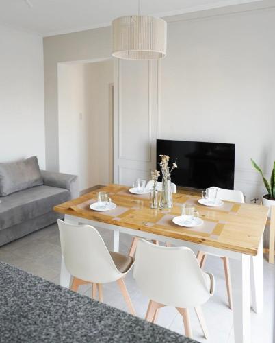 een eetkamer met een houten tafel en witte stoelen bij HomeRental SF (departamentos céntricos en alquiler temporario) in Santa Fe