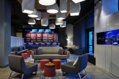 a lobby with couches and chairs and a bar at Aloft Miami Aventura in Aventura