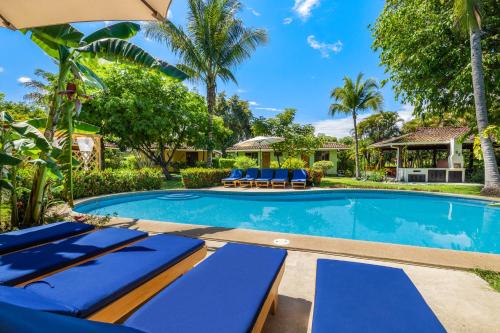 uma piscina com espreguiçadeiras azuis e uma casa em Hotel Bahia Esmeralda em Potrero