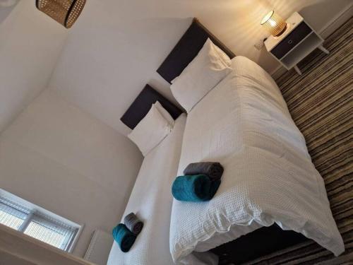a bedroom with a bed with white sheets and blue pillows at Stable Mews: A Unique Natural Country Feel. in Hull