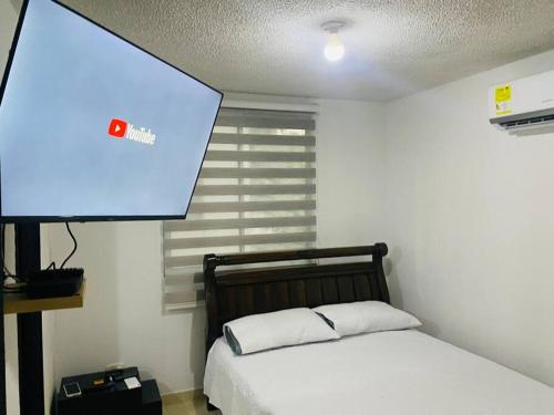 een slaapkamer met een bed en een projectiescherm bij Hermoso lugar para descansar in Barranquilla