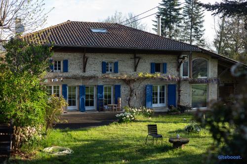 una casa con puertas azules y una silla en el patio en La Demeure de Camille, 