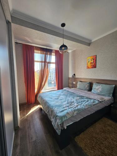 a bedroom with a large bed and a window at ApartHotel city centrum in Chişinău