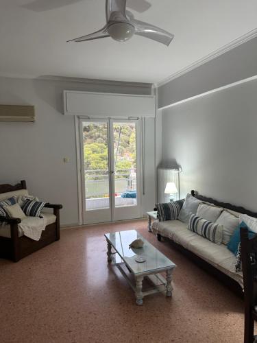Athens Riviera-SEAVIEW Apartment-Walk to the beach-Minutes away from Sounio-Updated 2023! في Áyios Yeóryios: غرفة معيشة مع أريكة وطاولة قهوة