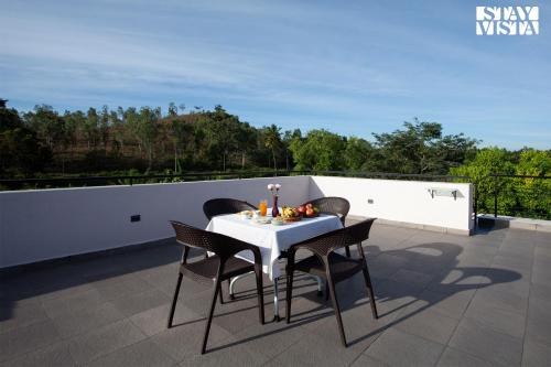 a white table and chairs on a roof at StayVista at Ava - The Country House with Breakfast & Miniature Golf in Mysore