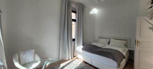 - une chambre blanche avec un lit et une table en verre dans l'établissement Stilvolle Ferienwohnung Dresden, à Dresde