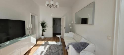 Una sala de estar con un sofá y un televisor de pantalla plana. en Stilvolle Ferienwohnung Dresden, en Dresden