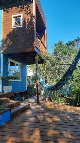 a house with a hammock on the porch of it at Nairandey in La Pedrera