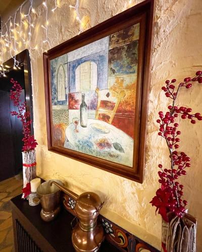 a painting hanging on a wall with a sink at Le Cedrus Hotel in Al Arz