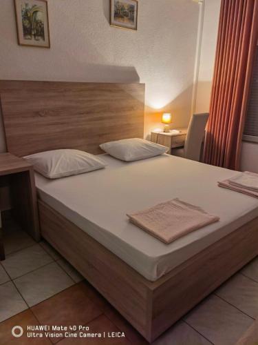 a bedroom with a large bed with a wooden headboard at Lovely Bosnian Home in Mostar