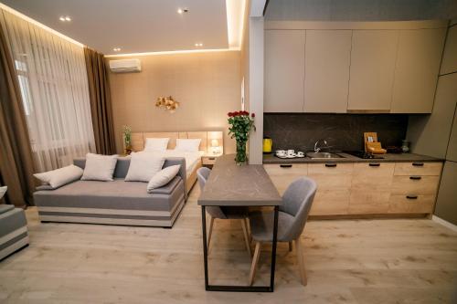 uma cozinha e sala de estar com um sofá e uma mesa em Apart-Hotel CARDINAL em Truskavets