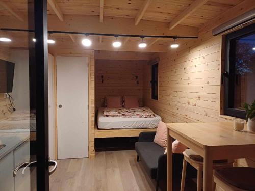 Habitación pequeña con cama y mesa en La roulotte de Soiron, en Pepinster