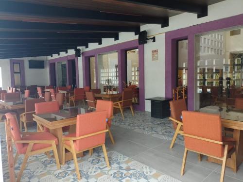 restauracja z drewnianymi stołami, krzesłami i oknami w obiekcie HOTEL BOUTIQUE CASA DEL BOSQUE w mieście Tlaxcala de Xicohténcatl