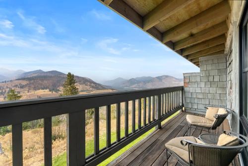 a balcony with chairs and a view of mountains at Sun Mountain Lodge in Winthrop