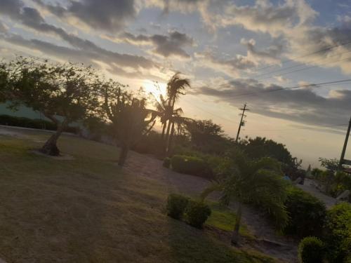 a sunset in a park with trees and bushes at Pousada Vale Encantado in Serra de São Bento
