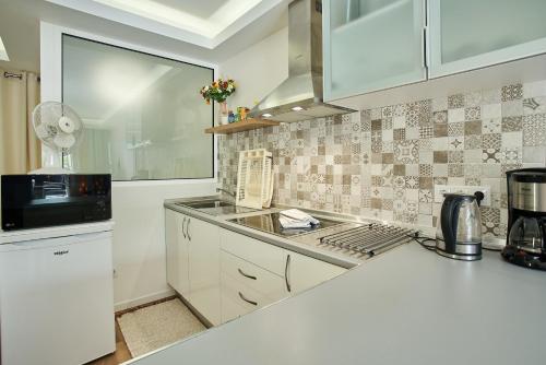 a kitchen with white cabinets and a sink at Villa Formosa in Funchal