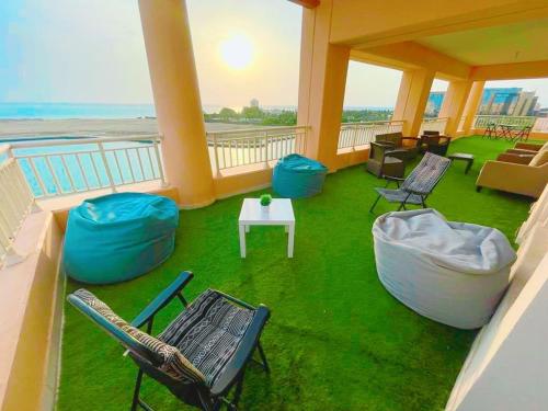 a balcony with chairs and a table and a view of the ocean at رويال مارينا بانوراما ثلاث غرف Royal Beach family and businesses in King Abdullah Economic City