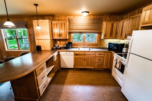 a kitchen with wooden cabinets and a white refrigerator at Sun Mountain Lodge in Winthrop