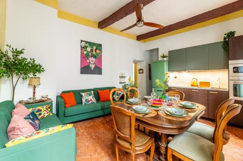 a living room with a table and a green couch at Casa Antoinette-Invitation vintage au-dessus du Vieux-Port in La Ciotat