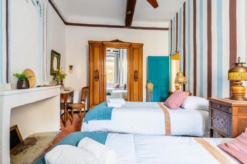 a bedroom with two beds and a fireplace at Casa Antoinette-Invitation vintage au-dessus du Vieux-Port in La Ciotat