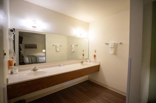 a bathroom with two sinks and a large mirror at Mountain Vista Hotel in West Yellowstone