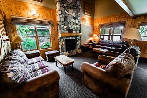 a living room with couches and a stone fireplace at Sun Mountain Lodge in Winthrop
