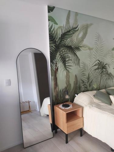 een slaapkamer met een spiegel, een bed en een tafel bij Palmas de Recoleta in Buenos Aires