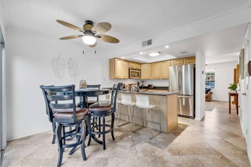 uma cozinha com uma mesa e cadeiras e um frigorífico em Beachside Duplex off Flagler with FREE garage parking em New Smyrna Beach