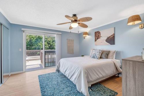 um quarto com uma cama e uma ventoinha de tecto em Beachside Duplex off Flagler with FREE garage parking em New Smyrna Beach