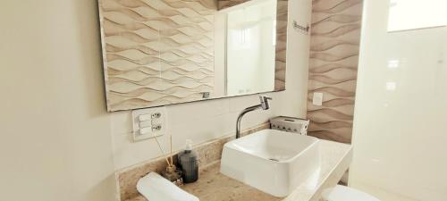 カボ・フリオにあるCasa aconchegante! perto de Búzios e Cabo Frioの洗面台と鏡のあるバスルーム