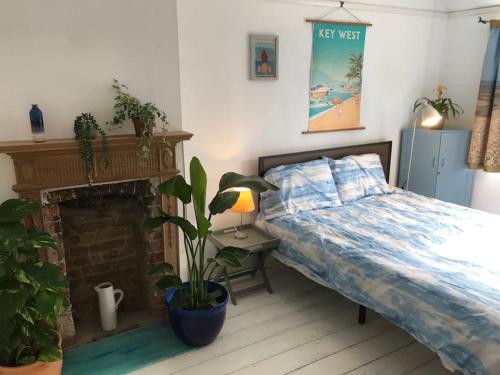 a bedroom with a bed and a fireplace at Whitstable Link in Whitstable