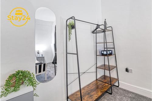 ein Spiegel steht für ein Badezimmer mit einem Regal in der Unterkunft Alton Suite in Crewe
