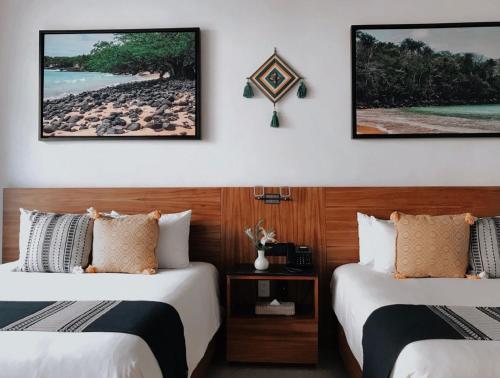 a hotel room with two beds and a beach at Ximena Hotel Boutique in Sayulita